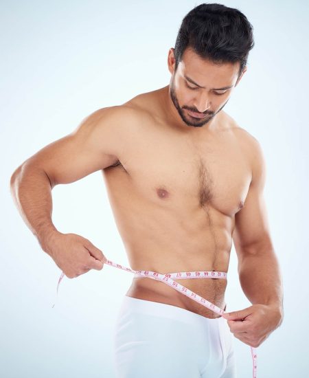Man, body or measuring tape on waist on studio background for weight loss management, fat control o.